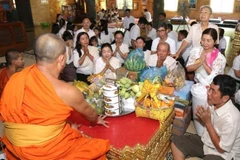 Người dân Campuchia thực hiện nghi thức cúng dường chư tăng tại tại Chùa Svay Romeat tỉnh Siem Reap. (Ảnh: AKP/TTXVN)
