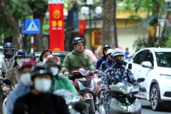 Gió mùa về kèm mưa nhỏ khiến nhiều người dân phải mặc thêm áo khoác vào sáng 10/10. (Ảnh: An Đăng/TTXVN)