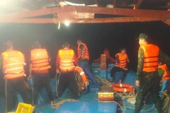 Cán bộ, chiến sỹ Đồn Biên phòng Khánh Hội hỗ trợ đưa thuyền viên bị thương ở chân đi cấp cứu. (Ảnh: Đơn vị cung cấp)