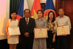Các cá nhân được tặng giấy khen chụp ảnh lưu niệm cùng đại diện Đại sứ quán Việt Nam tại Cộng hòa Séc. (Ảnh: Ngọc Biên/TTXVN)