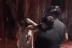 Hai người đánh cô gái mặc áo trắng. (Ảnh cắt từ clip)