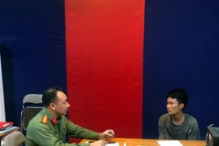 Cơ quan công an làm việc với đối tượng đưa thông tin sai sự thật lên mạng xã hội. (Ảnh: TTXVN phát)