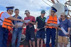 Lực lượng chấp pháp trên biển của tỉnh Bà Rịa-Vũng Tàu tuyên truyền về IUU cho ngư dân thành phố Vũng Tàu trước khi tàu xuất bến ra khơi đánh bắt thủy sản. (Ảnh: Hoàng Nhị/TTXVN)