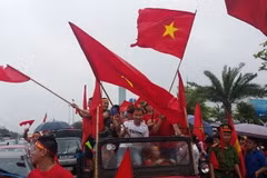 Trên dọc tuyến đường vào sân bay quốc tế Nội Bài, rất đông người hâm mộ đã đeo băng rôn và mang cờ hoa ra đón các cầu thủ Đội tuyển Olympic Việt Nam. (Nguồn: Quang Quyết/TTXVN)