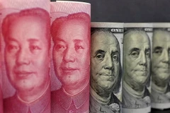 Đồng tiền giấy 100 Nhân dân tệ (trái) và đồng đôla Mỹ ở Bắc Kinh. (Nguồn: Reuters/ TTXVN)