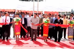 Tổng Bí thư, Chủ tịch nước Lào Chummaly Saynhasone và các vị đại biểu cắt băng khánh thành trường Trung học Xaysettha. (Ảnh: Hoàng Chương/Vietnam+)