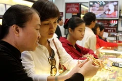 Mua bán vàng tại cửa hàng vàng Bảo tín Minh Châu, Hà Nội. (Ảnh: Trần Việt/TTXVN)