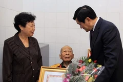 Chủ tịch nước Trương Tấn Sang trao tặng danh hiệu Anh hùng Lực lượng vũ trang nhân dân cho ông Nguyễn Đức Hùng. (Ảnh: Thanh Vũ/TTXVN)