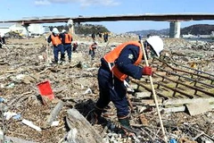 Cảnh sát tìm kiếm nạn nhân sóng thần hai năm trước đây tại cửa sông Kyu Kitakami ở Ishinomaki, tỉnh Miyagi ngày 11/3. (Nguồn: AFP/TTXVN)