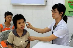 Kiểm tra sức khỏe thường xuyên cho các em nhiễm chất độc da cam/ dioxin. (Ảnh: Nguyễn Thủy/TTXVN)