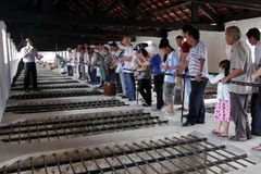 Du khách tham quan khu di tích "chuồng cọp" ở Nhà tù Côn Đảo, nơi trước đây từng giam cầm những chiến sỹ cách mạng. (Ảnh: Ngọc Hà/TTXVN)