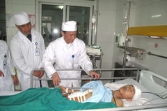 Các bác sỹ thăm bệnh nhân Vũ Văn Minh. (Ảnh: Mạnh Khánh/Vietnam+)