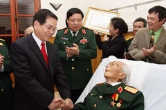 Chủ tịch nước Nguyễn Minh Triết và Đảng ủy quân sự Trung ương chúc mừng Đại tướng Võ Nguyên Giáp nhận Huy hiệu 70 năm tuổi Đảng. (Ảnh: Nguyễn Khang/TTXVN)