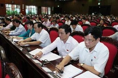 Đại biểu Quốc hội ấn nút biểu quyết Nghị quyết phê chuẩn quyết toán ngân sách nhà nước năm 2011. (Ảnh: Lâm Khánh/TTXVN)