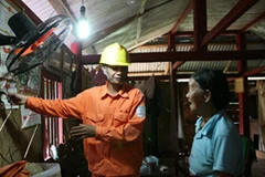 Công nhân điện lực Lai Châu hướng dẫn người dân Mường Tè sử dụng điện trong dự án dùng vốn vay của ADB. (Ảnh: Ngọc Hà/ TTXVN)