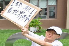 Trương Huệ Quyền với tấm biển “Nghỉ việc để xem World Cup” (Nguồn: Chinadaily)