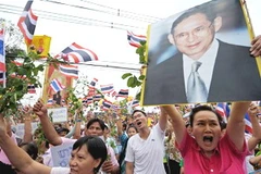 Những người biểu tình ủng hộ chính phủ giơ ảnh nhà vua Thái Lan tại trung tâm thủ đô Bangkok. (Ảnh: Getty Images)