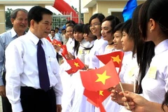 Chủ tịch nước Nguyễn Minh Triết chúc mừng học sinh trường Him Lam có nơi học tập mới. (Ảnh: Duy Khương/TTXVN)