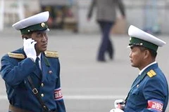 Một sỹ quan cảnh sát Triều Tiên (trái) sử dụng điện thoại di động ở Bình Nhưỡng. (Nguồn: Reuters)