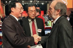 Trưởng đoàn Nguyễn Văn Thành (trái) trao điện mừng của Đảng Cộng sản Việt Nam tới đại diện Đảng Cộng sản Pháp. (Ảnh: Lê Hà/Vietnam+)