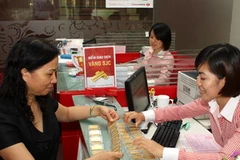 Giao dịch mua bán vàng ở ngân hàng Techcombank. (Nguồn: TTXVN)