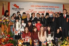 Đại diện ban chấp hành Hội tặng quà và chụp ảnh lưu niệm với các cháu con em các thành viên của hội tại buổi gặp mặt. (Ảnh: Thanh Hải/Vietnam+)