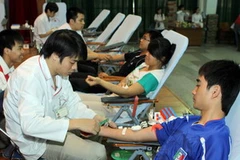 Thanh niên hiến máu tình nguyện. (Ảnh: Đình Trân/TTXVN)