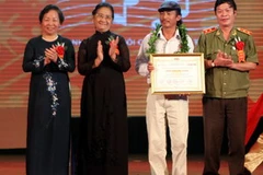 Phó Chủ tịch nước Nguyễn Thị Doan trao giải nhất cho nhạc sĩ Khánh Vinh (áo trắng) với ca khúc "Lời ru". (Ảnh: Nhật Anh/TTXVN)