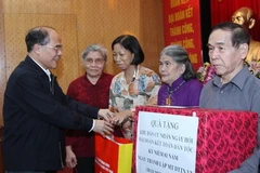 Chủ tịch Quốc hội Nguyễn Sinh Hùng tặng quà cho các gia đình chính sách tại buổi lễ. (Ảnh: Nhan Sáng/TTXVN)