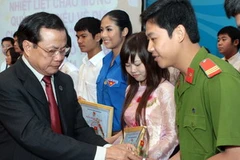 Bí thư Thành ủy Hà Nội Phạm Quang Nghị trao phần thưởng và bằng khen cho các thanh niên tiêu biểu. (Ảnh: Đình Trân/TTXVN)