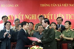 Lãnh đạo TTXVN và Bộ Công an trao đổi văn kiện Nghị quyết liên tịch phối hợp thông tin, tuyên truyền giữa hai đơn vị. (Ảnh: Doãn Tấn/TTXVN)