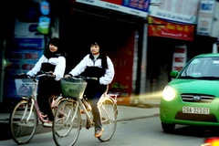 Học sinh trung học phổ thông đến trường khi trời vẫn còn chưa sáng rõ. (Ảnh: Quý Trung/TTXVN)