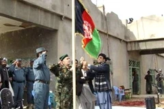 Quan chức và đại diện quân đội Afghanistan ở tỉnh Helmand kéo cờ tiếp quản thị trấn Marjah. (Ảnh: AP)