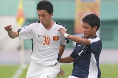 Pha tranh bóng giữa Nguyễn Minh Tuyên (30, U19 Việt Nam) và Mansor (4, Malaysia). (Ảnh: Quang Nhựt/TTXVN)