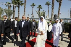 Thủ tướng của phong trào Hamas Ismail Haniya (giữa, bên trái) đón Quốc vương Qatar Hamad bin Khalifa al-Thani (giữa, phải) tới thăm dải Gaza. (Nguồn: AFP)