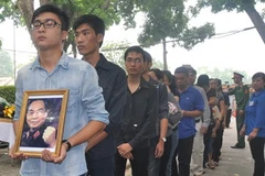 Trong dòng người vào mặc niệm Đại tướng Võ Nguyên Giáp có nhiều bạn trẻ mang theo tấm chân dung Đại tướng với sự thành kính. (Ảnh: Việt Đức/Vietnam+)