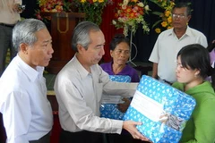 Chủ tich Ủy ban Trung ương Mặt trận Tổ quốc Việt Nam, Huỳnh Đảm thăm hỏi tặng quà cho bà con vùng lũ. (Ảnh: Đức Ánh/TTXVN)