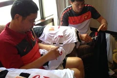 Trưởng đoàn Dương Nghiệp Khôi và trợ lý Phạm Như Thuần tự tay may băng tang trên áo đấu của các cầu thủ.