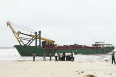 Chiếc tàu bị sóng biển đánh dạt vào bờ biển của xã Triệu Lăng, huyện Triệu Phong. (Ảnh Hồ Cầu/TTXVN)