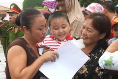 Phạm nhân được đặc xá (trái) gặp lại người thân trong ngày nhận quyết định đặc xá. (Ảnh: Trọng Đức/TTXVN)