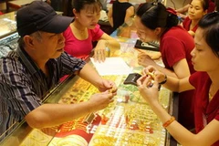 Mua bán vàng tại Công ty Vàng Bảo Tín Minh Châu. (Ảnh: Trần Việt/TTXVN)