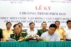 Bộ trưởng Đinh La Thăng và Chủ tịch Hội Cựu chiến binh Việt Nam Nguyễn Văn Được ký văn bản Chương trình phối hợp. (Ảnh: Hoàng Hùng/TTXVN)