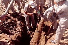 Đội rà phá bom mìn lưu động tỉnh Quảng Trị đưa quả bom lên mặt đất để xử lý. (Ảnh: Hồ Cầu/TTXVN)