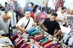 Khách chọn mua quần áo tại hội chợ. (Ảnh: Quang Quyết/TTXVN)