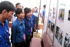 Đoàn viên, thanh niên xem tài liệu, hình ảnh về Lý Tự Trọng trưng bày tại triển lãm. (Ảnh: Công Tường/'TTXVN) 