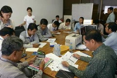 Quan chức NEC, đại diện các đảng chính trị và tổ chức phi Chính phủ kiểm tra kết quả bầu cử Quốc hội ngày 3/8. (Nguồn: AFP/TTXVN)