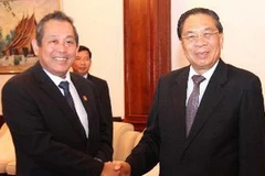 Tổng Bí thư, Chủ tịch nước Lào Chummaly Saynhasone tiếp Bí thư Trung ương Đảng, Chánh án Tòa án ND tối cao Trương Hòa Bình. (Ảnh: Hoàng Chương/TTXVN)