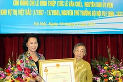 Bộ Trưởng Bộ Lao động-Thương binh và Xã hội Nguyễn Thị Kim Ngân trao tặng Huân chương cho vợ ông Lê Đình Thiệp. (Ảnh: Hữu Việt/TTXVN)