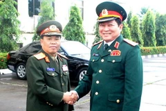 Trung tướng Sengnoun Saynhalat đón Trung tướng Ngô Xuân Lịch. (Ảnh: Hoàng Thanh Chương/Vietnam+)