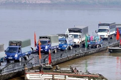 Các phương tiện giao thông đi trên cầu phao qua sông Hồng. (Ảnh: Trọng Đức/TTXVN) 